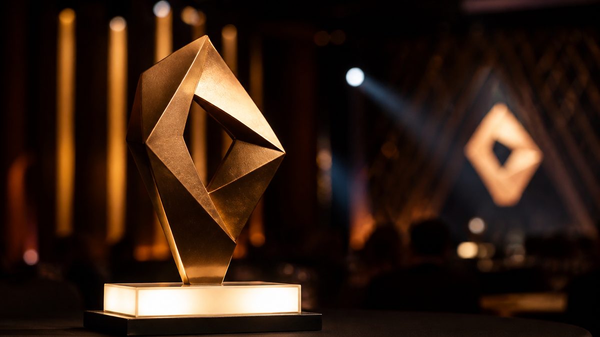 Galardón corporativo impreso en 3D con acabado metalizado sobre la mesa de una gala de empresa
